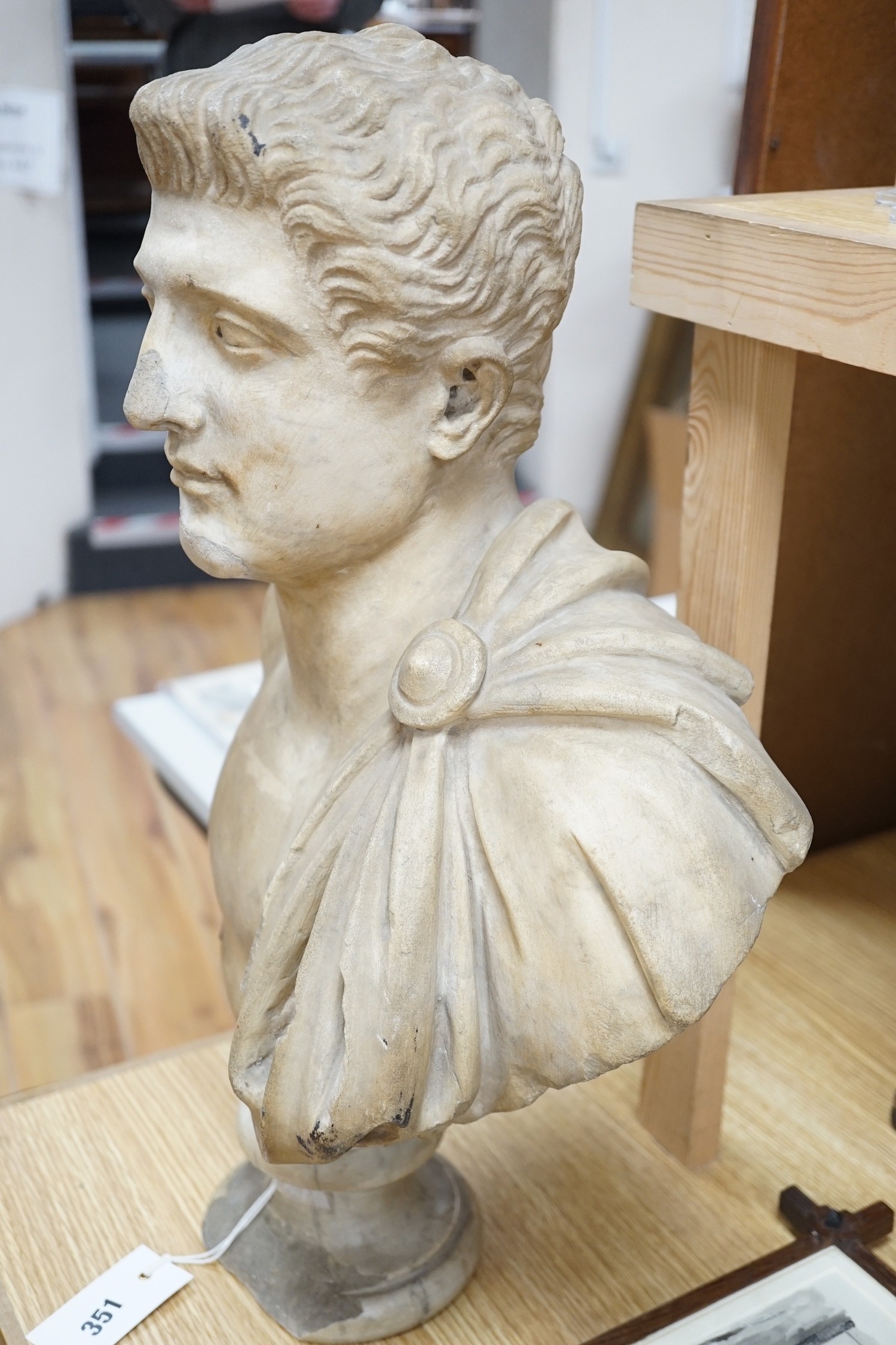 After the Antique marble bust of a Roman man wearing a Chlamys with a buckle at the shoulder, later socle and repairs, 54cm tall